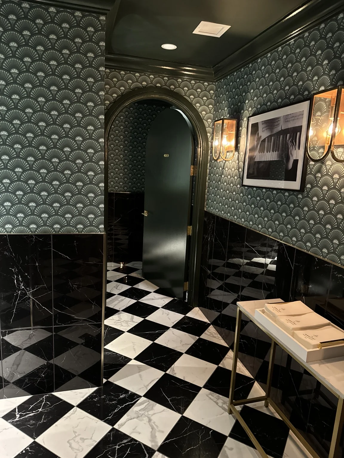 Dark art deco inspired room with patterned walls and checkerboard floor