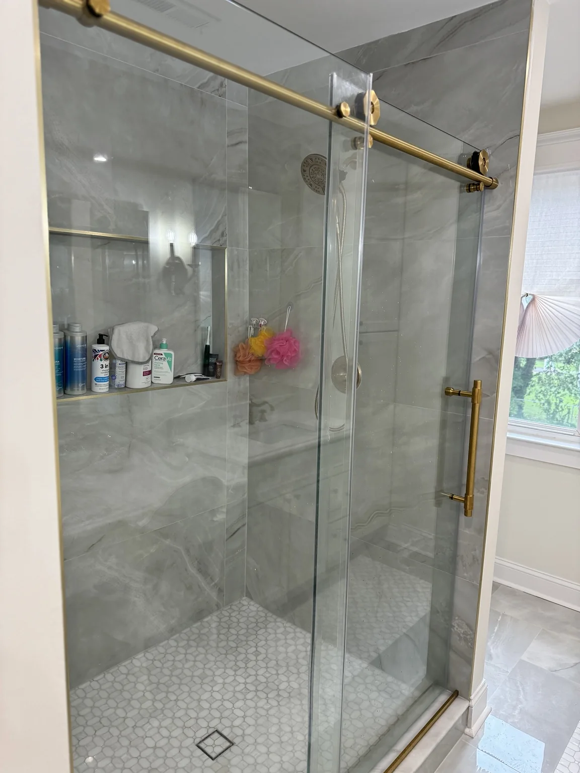 Large format shower tile with brass glass hardware