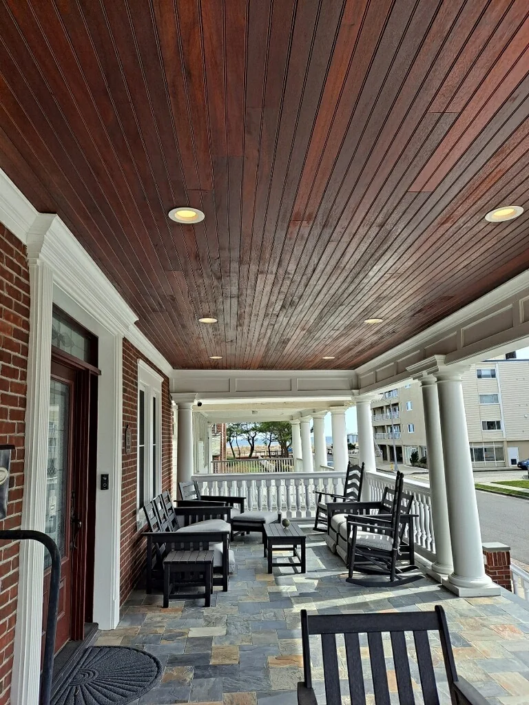 Covered front porch with wood ceiling and stone floor